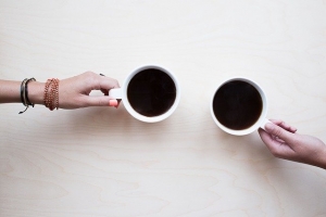 Két csésze kávé két barátnő kezében